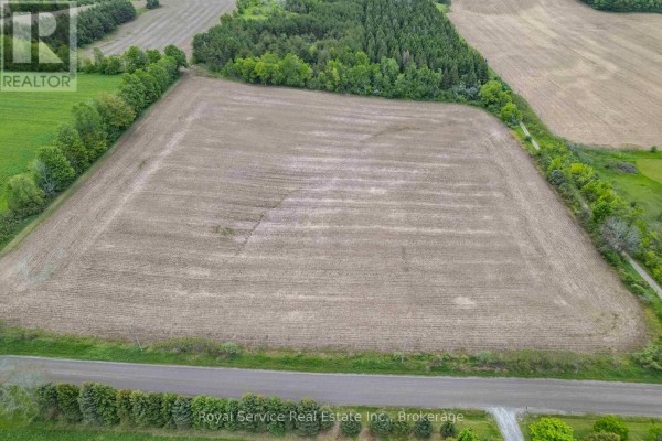 Drone shot of cultivated farmland bordered by mature trees and green fields. - Pt Lt 6 Con 6 7th Line, Port Hope
