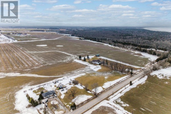 Aerial view of the expansive farmland with a farmhouse and surrounding fields. - Pt N 1/2 Lt 19 10 Concession, Springwater