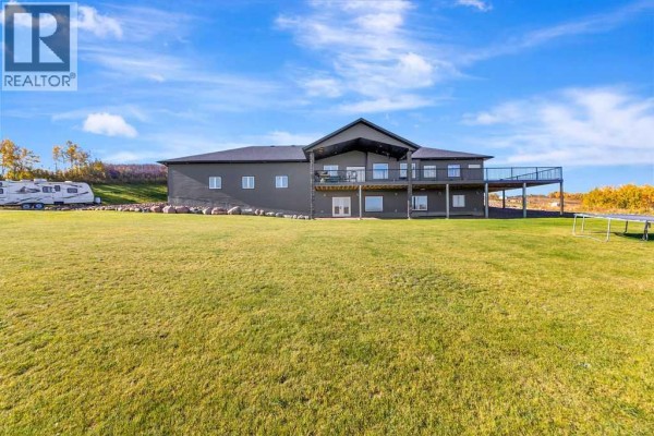 Rear view of the grey house with a large deck and a vast lawn. - Pt Nw 8-45-1-w4, Rural Wainwright No  61, M D  Of