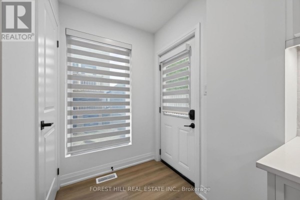 Entrance area with white walls, doors, and wide plank flooring. - R - Garden - 221 Churchill Avenue, Toronto
