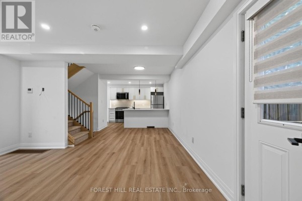Open concept living area with stairs, kitchen, and dining space. - R - Garden - 221 Churchill Avenue, Toronto