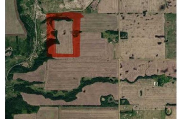 Aerial view of farmland with a section highlighted in red next to a wooded area. - Range Road 203, Rural Camrose County
