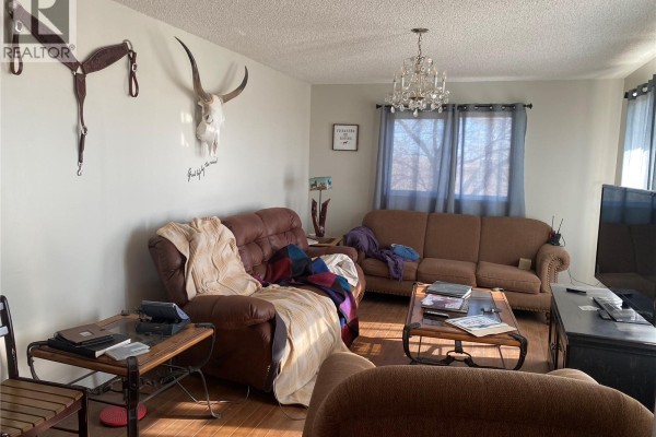 Living room with two sofas, a recliner, and decorative steer skull mounted on the wall. - Rapley Arena Quarter, Val Marie Rm No  17