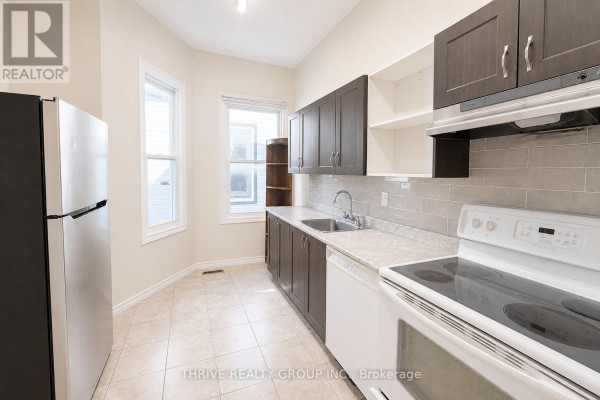 Kitchen with stainless steel refrigerator, dark wood cabinets, and white appliances. - Rear - 220 Hamilton Road, London East