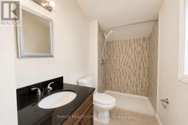 Bathroom with a vanity, toilet, and a tiled walk-in shower. - Rear - 220 Hamilton Road, London East