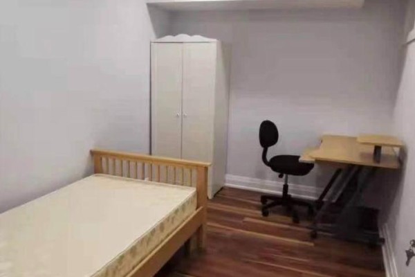 A bedroom with a wooden bed frame, closet, desk, and black office chair on wood floors. - Renovated Bedroom Bsmt - 16 Ross St Street, Toronto