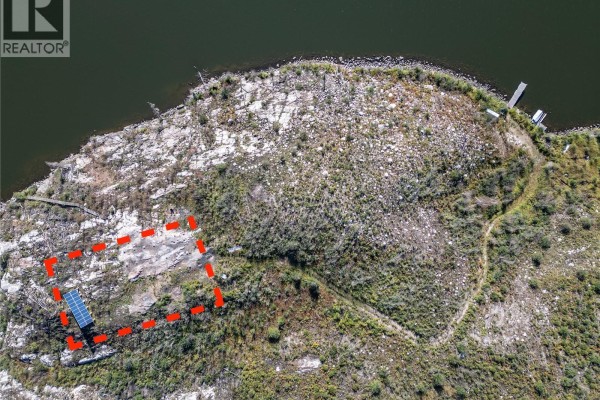 Solar panels are installed on a rocky, uneven terrain with remnants of concrete foundations. - Reynold's Bay Titled Lot, Northern Admin District
