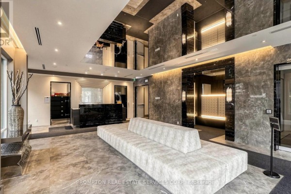 Lobby area with a reception desk, mailboxes, modern sofa, and marble tile flooring. - Rg7 - 396 Highway 7 E, Richmond Hill