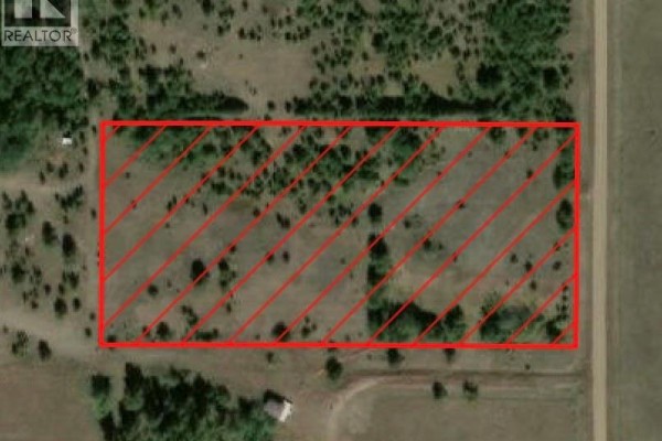 Aerial view of a rectangular property outlined in red, showing a grassy field and surrounding trees. - Rm Of Duck Lake Lot, Duck Lake Rm No  463