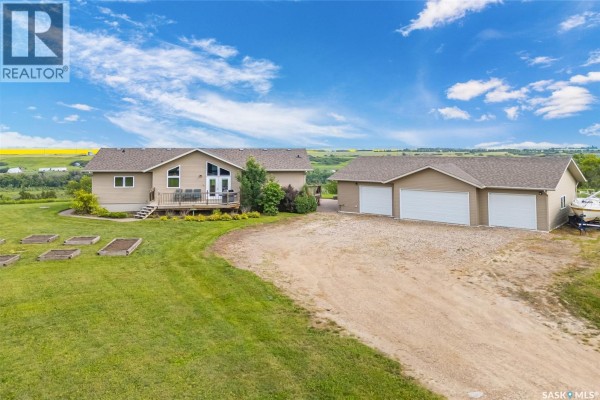 Wide aerial shot of the riverfront property showing the house, garage, and surrounding landscape. - Roberts Riverfront Acreage, South Saskatchewan River