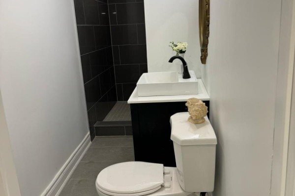 A bedroom with a queen-size bed, two black nightstands, and a woven wall hanging. - Room 2 - 248 Crossland Gate, Newmarket