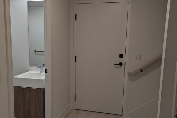Interior entryway with a closed door, a small powder room, and stairs. - S104 - 180 Mill Street, Toronto