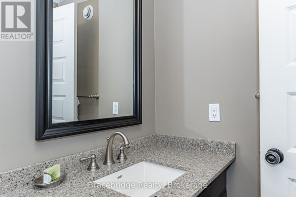 Close-up of a bathroom vanity with a granite countertop and white sink. - Sandfield 3 W3 - 3876 Muskoka Rd 118 Highway W, Muskoka Lakes
