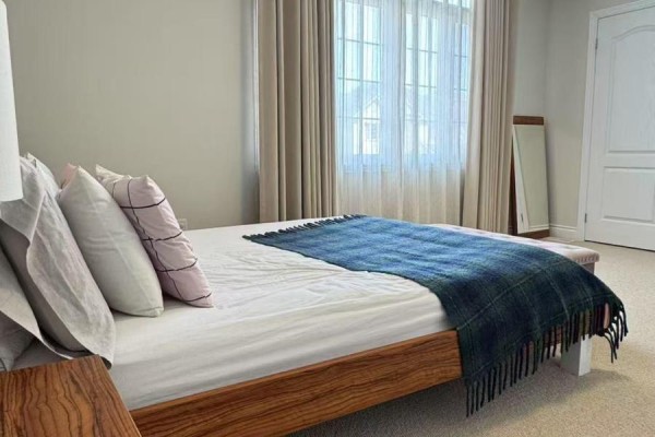 View of a bed with pillows and a blue plaid blanket in a bedroom. - Second Floor Room A - 936 Goring Circle, Newmarket
