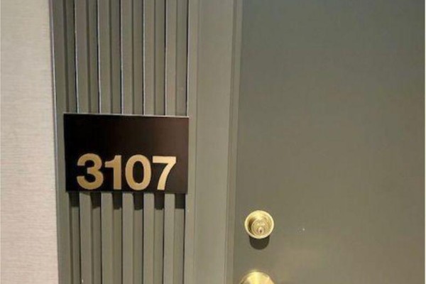 Unit 3107 apartment door with gold-colored hardware and a ridged grey accent wall. - Shared Unit 3107 - 898 Portage Parkway, Vaughan
