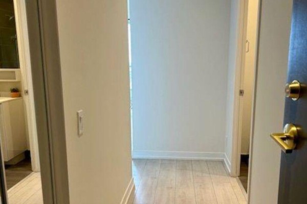Interior hallway with light wood laminate flooring and doorways to other rooms. - Shared Unit 3107 - 898 Portage Parkway, Vaughan