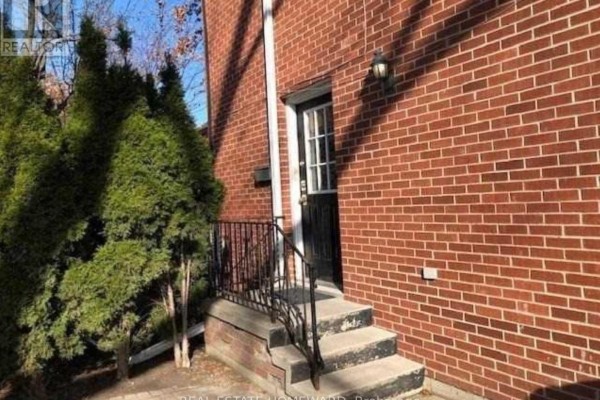 Side entrance with brick wall, stone steps, and greenery - Side - 274 Rumsey Road, Toronto