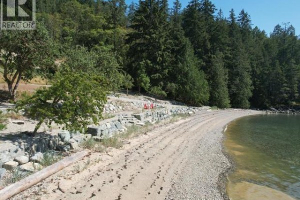 Sandy beach with a rocky seawall and steps leading up to a treed slope. - Sl 18 Sarah Point Road, Powell River
