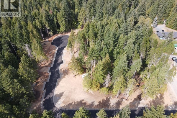 Aerial view of a wooded lot with cleared building sites and paved access road. - Sl7 Essex Way, Qualicum Beach