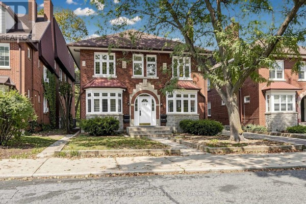 Front exterior view showing a multi-family home with red brick facade, white windows, and mature trees. - South 2nd - 163 Highbourne Road, Toronto