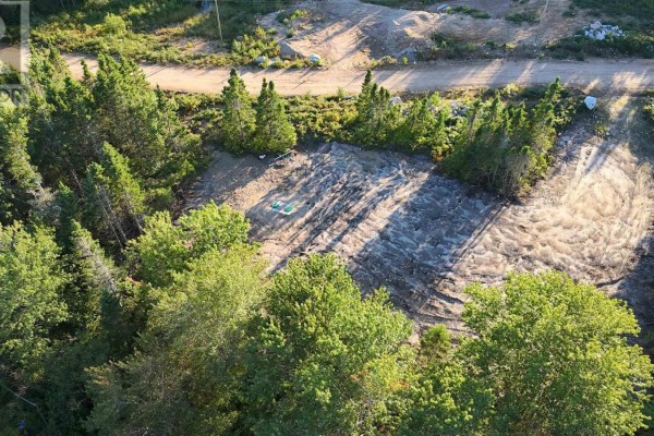 Cleared land with two green septic tanks on a concrete pad. - Spruce Lane, Ingonish