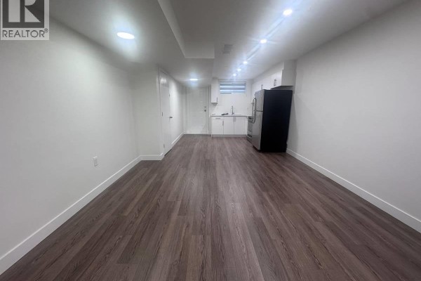Bedroom with white walls, open closet, and doorway leading to the living area. - Suite 10321 243 St, Maple Ridge