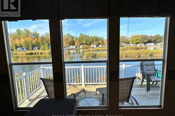 Open living space with kitchen, dining area, and seating, featuring wood flooring. - T103 - 7489 Sideroad 5 E, Wellington North