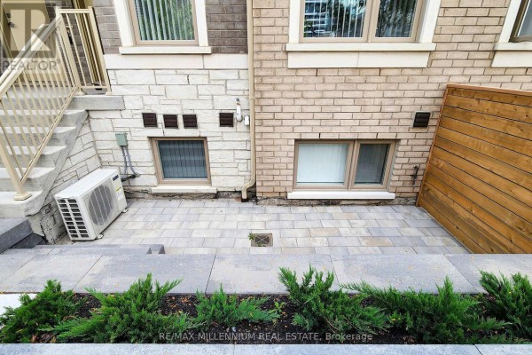 View of a paved patio area and exterior stairs with landscaping in the foreground. - Th 350 - 100 Honeycrisp Crescent, Vaughan
