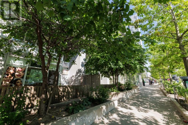 Street view of a commercial property with trees and a sidewalk. - Th02 - 60 Dan Leckie Way, Toronto