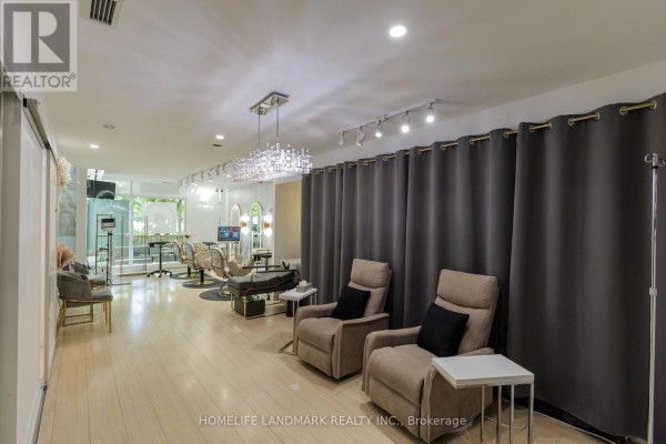 Interior view of a salon with comfortable seating, curtains, and salon chairs. - Th02 - 60 Dan Leckie Way, Toronto