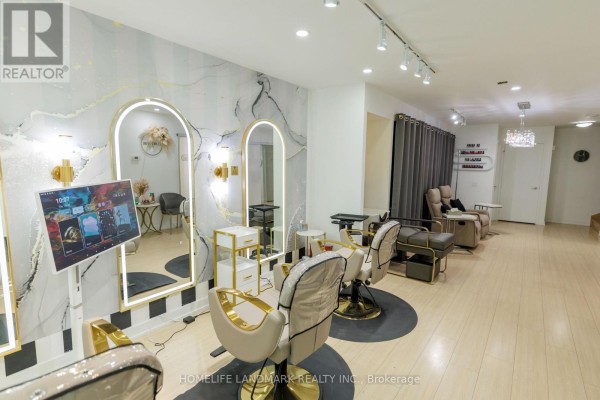 Salon interior with styling chairs, mirrors, and seating area with massage chairs. - Th02 - 60 Dan Leckie Way, Toronto