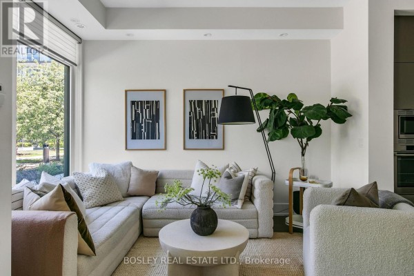 Close-up of sectional sofa pillows and a dark vase with green foliage. - Th05 - 51 Paul Lane Gardens, Toronto