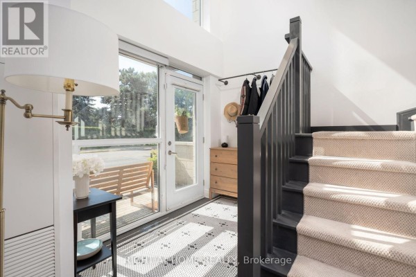 Interior view of entryway with stairs, dresser, and door to the outside. - Th10 - 1350 Kingston Road, Toronto