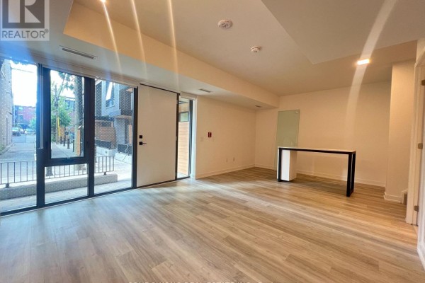 Living area with large windows, sliding glass door, and view of street. - Th110 - 28 Eastern Avenue, Toronto