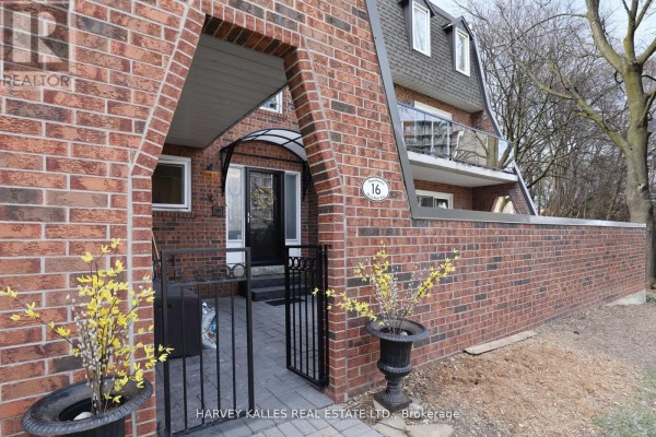 Side view of the townhouse with brick wall, decorative arch, and potted plants - Th16 - 18 La Rose Avenue, Toronto