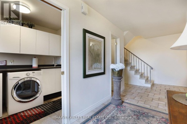 Laundry area with washer, decorative artwork, and tiled flooring - Th16 - 18 La Rose Avenue, Toronto