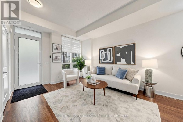 Living room entrance with white couch, wood flooring, and white staircase. - Th17 - 88 Sheppard Avenue E, Toronto
