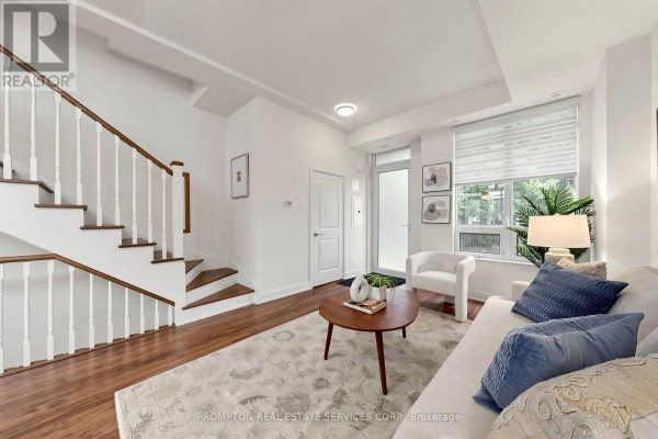 Living room with white couch, coffee table, and white staircase leading upstairs. - Th17 - 88 Sheppard Avenue E, Toronto