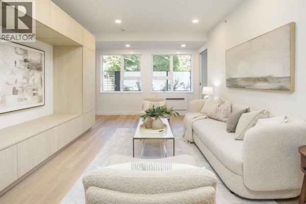 Living room with sofa, chairs, coffee table, and entertainment unit. - Th201 2471 St. George Street, Vancouver