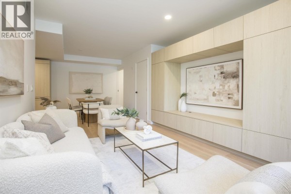 Living room with sofa, chairs, coffee table, and view to dining area. - Th201 2471 St. George Street, Vancouver
