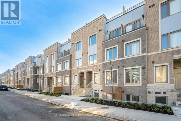View down a street showing a row of modern multi-story townhouses under a blue sky. - Th263 - 150 Honeycrisp Crescent N, Vaughan