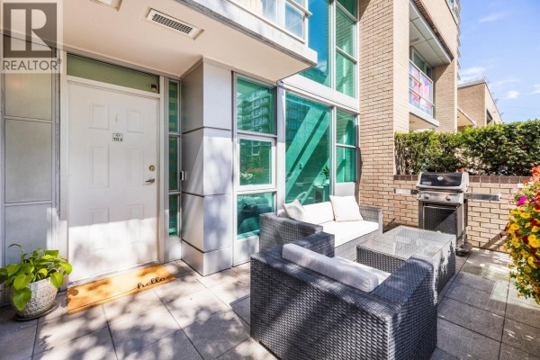 Townhouse patio with outdoor furniture, barbecue, flower boxes, and city buildings beyond. - Th8 168 E Esplanade Avenue, North Vancouver