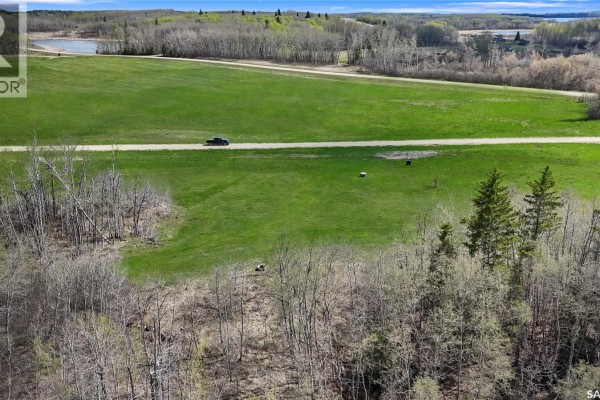 Overhead view of The Woodlands development with green fields and trees. - The Woodlands, Iroquois Lake