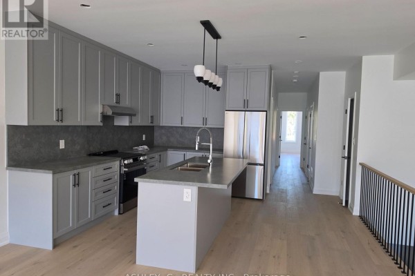 Modern kitchen with grey cabinetry, stainless steel appliances, and an island. - Third Floor - 701 Queen Street W, Toronto