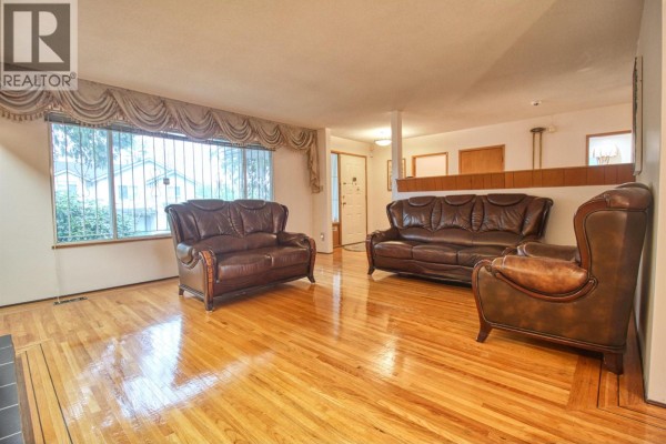 Living area with leather sofas, large window, and hardwood floors. - Top 904 E 52nd Avenue, Vancouver