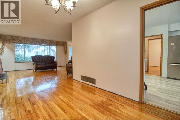 View from the living room towards hallway, showing hardwood floors and interior doors. - Top 904 E 52nd Avenue, Vancouver