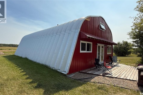Side view of a red and white quonset hut house with a wooden deck. - Turtleford Acreage., Mervin Rm No 499