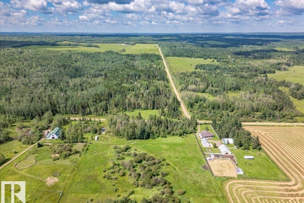 Aerial view of rural property with buildings, trees, fields, and a long gravel road. - Twp Rd 452a Rr 15, Rural Wetaskiwin County
