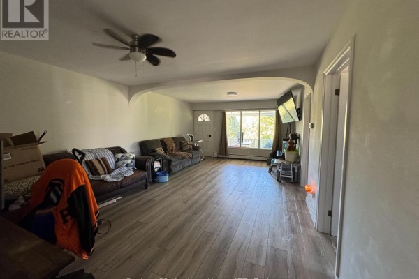 Living room with two sofas, wood-look flooring, ceiling fan, and a large window. - Unit 1 - 1022 Ridge Road, Fort Erie