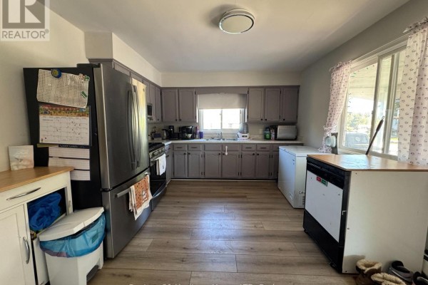 Kitchen with grey cabinets, stainless steel refrigerator, sink, and a view of the backyard. - Unit 1 - 1022 Ridge Road, Fort Erie